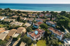 Vista aérea de una zona residencial costera con casas, una playa y el océano.
