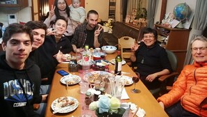A group of people seated around a dining table with various dishes, drinks, and condiments. - Full House Miyajima (Hatsukaichi)