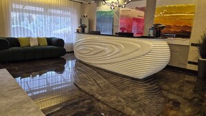 A modern lobby with a reception desk, a sofa, and a chandelier. - HL 309 Hotel (Tashkent)