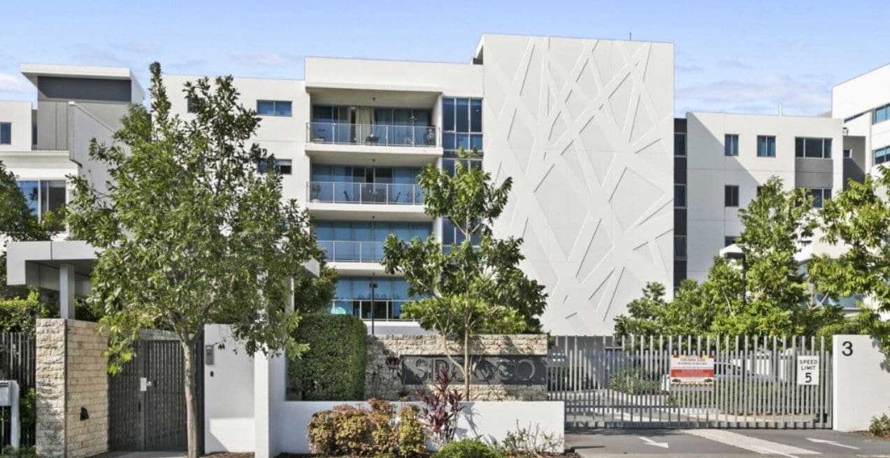 A modern building with multiple floors, large windows, and a geometric facade.