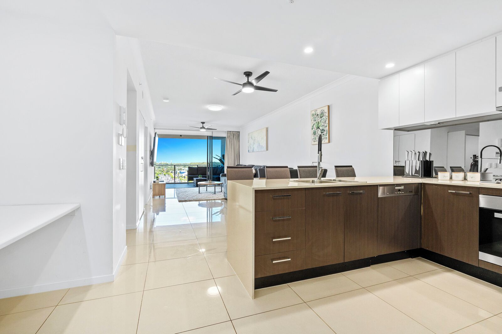 Una cocina moderna con una isla central, un comedor con vistas y un ventilador de techo.