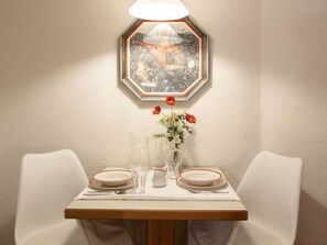 Uma mesa de jantar com pratos, copos e um vaso de flores.