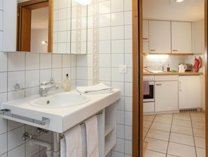 Une salle de bain équipée d’un lavabo, d’un miroir et d’un porte-serviettes.