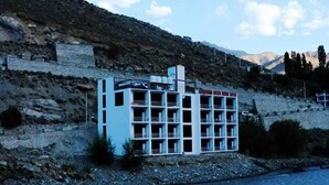 A modern building with a grid of rooms along a riverbank. - The Royal Kargil (Kargil)
