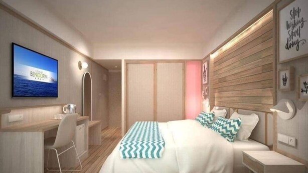 A modern bedroom with a bed, bedside tables, a desk, and a television. - The Royal Kargil (Kargil)