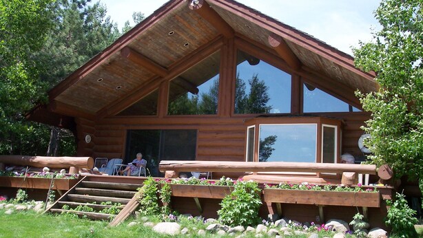 A log cabin with a large deck, a covered porch, and a stone staircase leading to the entrance. - Full Log Family Lodge - private dock/beach & fire pit (Hackensack)