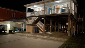 Une maison à deux étages dotée d’un balcon, d’un porche couvert et d’un escalier apparent.