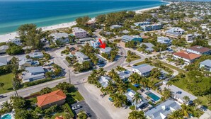An aerial view of a coastal residential area with houses, a beach, and a large body of water. - La Coconut: 1 Block to Beach! Dog Friendly! Ping Pong & Foosball, Heated Pool by Anna Maria Life (Holmes Beach)
