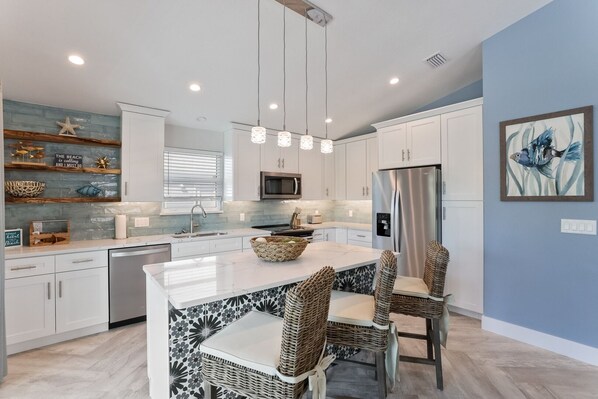 Enjoy cooking in this well-equipped kitchen with a central island, stainless steel appliances, and ample seating.