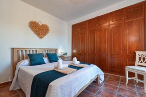 A hotel room with a bed, a wardrobe, and a chair.