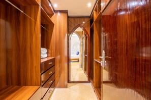Spacious walk-in closet with ample storage and a beautifully made bed nearby.