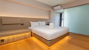 A modern hotel room with a bed, bedside table, and built-in bench. - lucky Elephant Hotel (Bangkok)