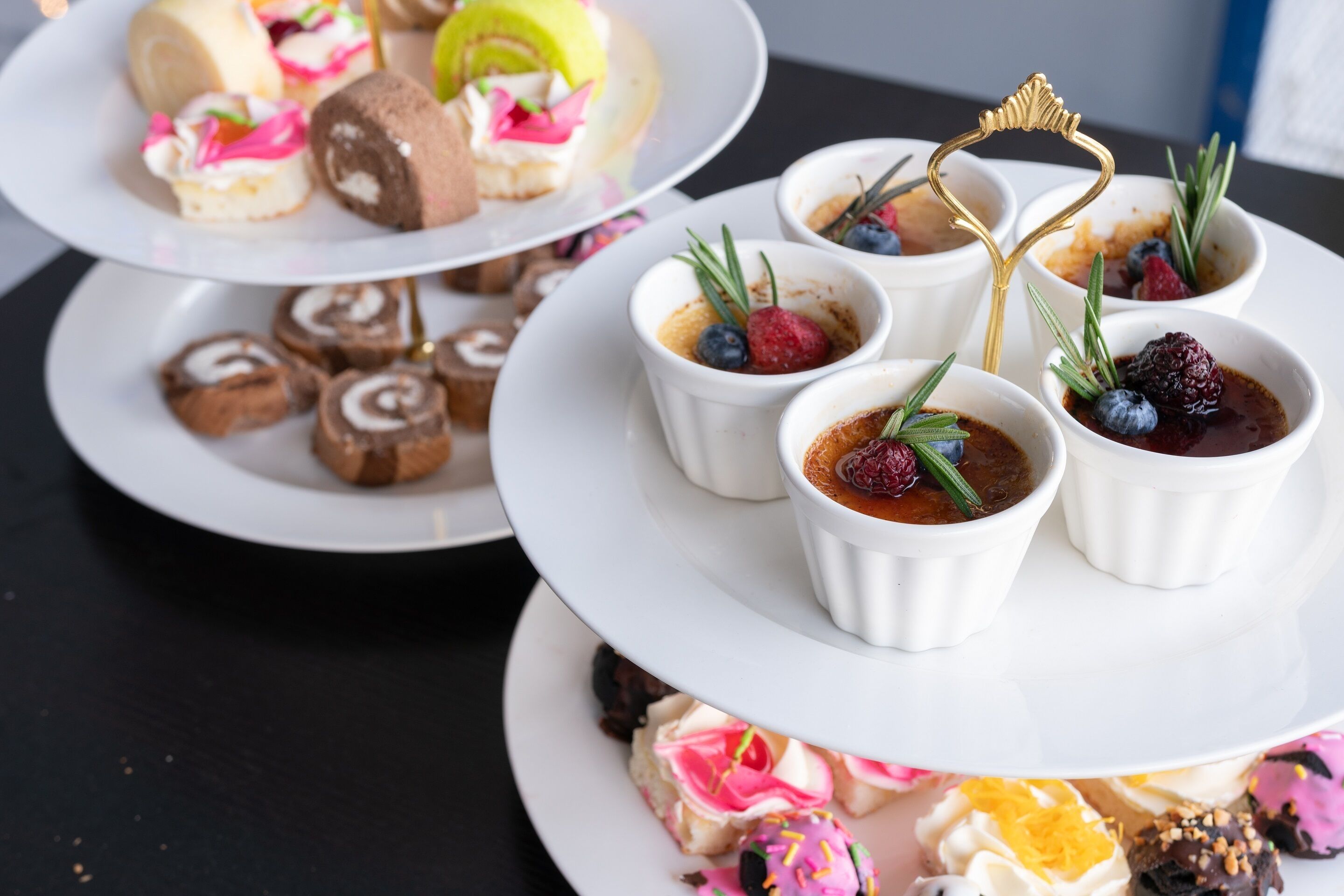 A dessert display with various pastries and desserts on white plates.