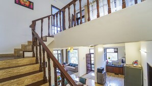A spacious living area with a wooden staircase, a kitchen, and a dining area. - Kamlia 3 BHK Villa By Dumnu Homes (Kasauli)