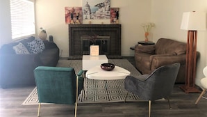 A living room with a fireplace, a sofa, a chair, and a coffee table.