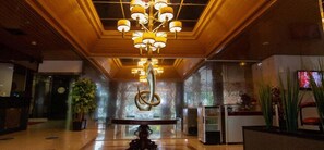 A lobby with a modern chandelier, a reception desk, and a large abstract sculpture. - Kumala Hotel (Bandung)