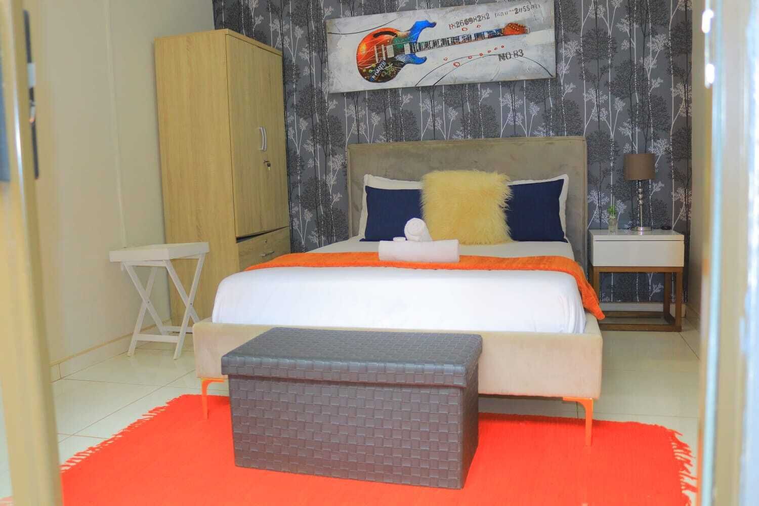 Une chambre à coucher comprenant un lit, une table de chevet, une armoire et une petite table.