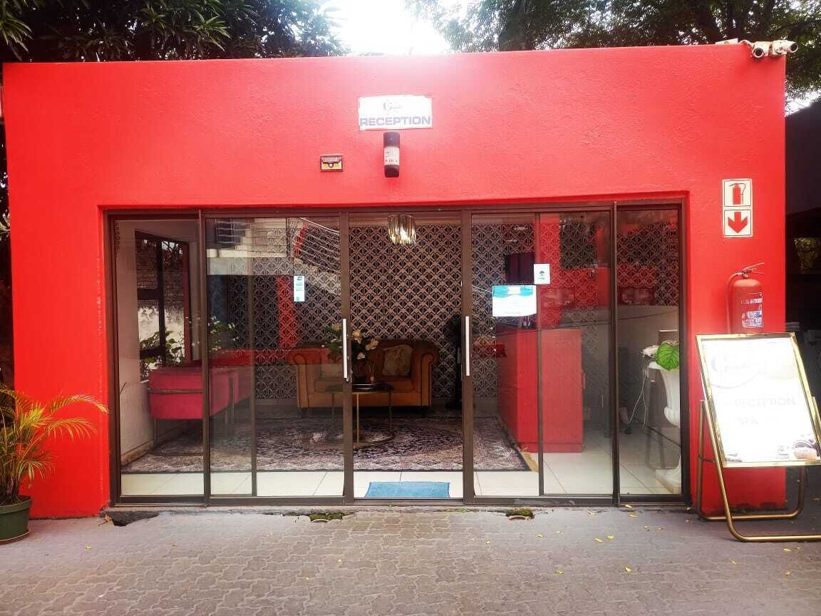 Un espace d’accueil à l’extérieur rouge, doté de portes vitrées et d’une enseigne indiquant qu’il s’agit de la réception.