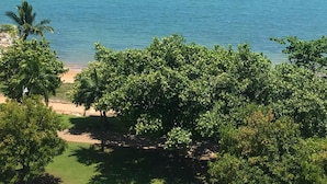 Un espace de stationnement avec des véhicules, une plage et une vue sur la mer.