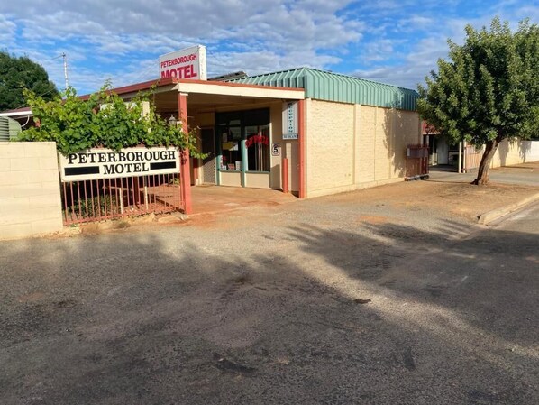 Le Peterborough Motel se distingue par son panneau indicateur, son entrée fermée par une grille et son bâtiment surmonté d’un toit végétalisé.