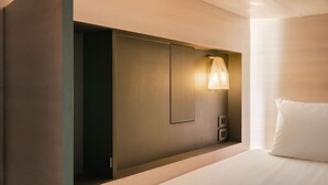 A modern hotel room with a large bed, built-in wardrobe, and a bedside lamp. - Speck Bangkok (Bangkok)