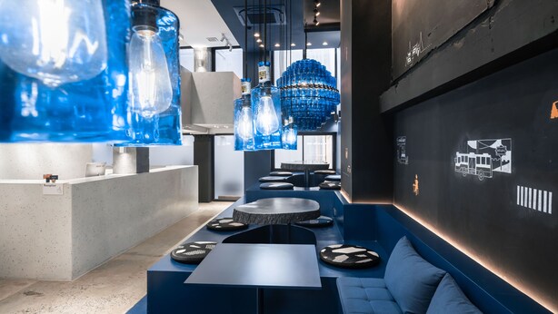 A modern interior with a reception desk, seating area, and decorative blue light fixtures. - Speck Bangkok (Bangkok)