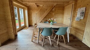 A wooden interior with a dining table, chairs, and a staircase. - Hotel Hochfirst (Lenzkirch)
