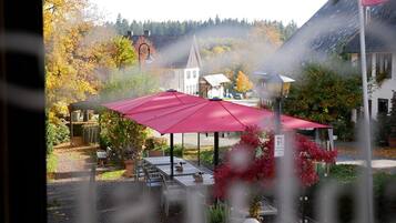 A dining area with outdoor seating and a red umbrella.