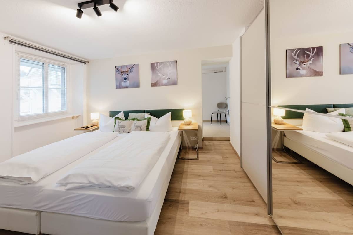 Habitación de hotel con dos camas, un escritorio y una silla.