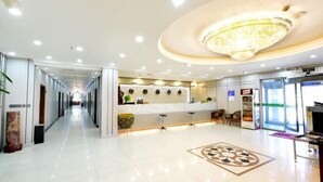 Eine Hotte Lobby mit einer langen Korridor, einem Empfangsbereich mit einer Theke und einer Chandelier.