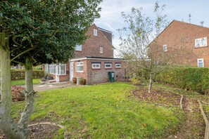 A residential property with a brick house, a front yard, and a tree. - Apartment King House Hayes (Hayes)