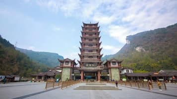 Un edificio pagoda tradicional de varios niveles, con fachada simétrica, ubicado en una zona montañosa bajo un cielo despejado.