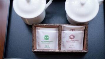Two white teapots and two tea packets on a tray.