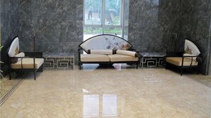Eine moderne Lobby mit Marmorboden, einem großen Fenster und zwei Sofas mit Kissen.