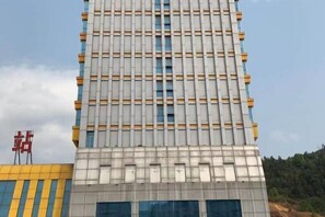 A multi-story building with a grid-like facade, featuring a mix of windows and solid panels. - Yage Hotel (Napo)