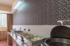 A buffet area with multiple food dispensers and a large serving pot.