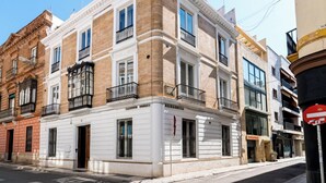 A corner building with a white facade, multiple balconies, and a sign indicating 'Albereda'. - Hostal Roomsole (Seville)