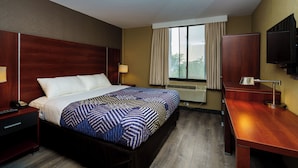 A hotel room with a bed, bedside tables, a desk, a TV, and a window with curtains. - Sky Hotel Flushing/LaGuardia Airport (Flushing)