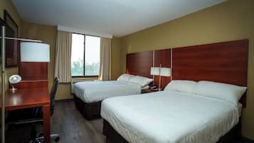 A hotel room with two beds, a desk, a chair, and a window with curtains.