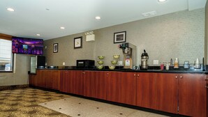 A hotel kitchen with a wooden counter, a coffee machine, and a microwave. - Sky Hotel Flushing/LaGuardia Airport (Flushing)