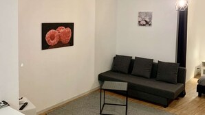 Ett modernt vardagsrum med en grå soffa, ett litet svart bord och en grå matta.