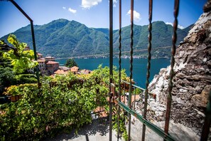 A view of a mountainous landscape with a bridge, a body of water, and buildings in the foreground.