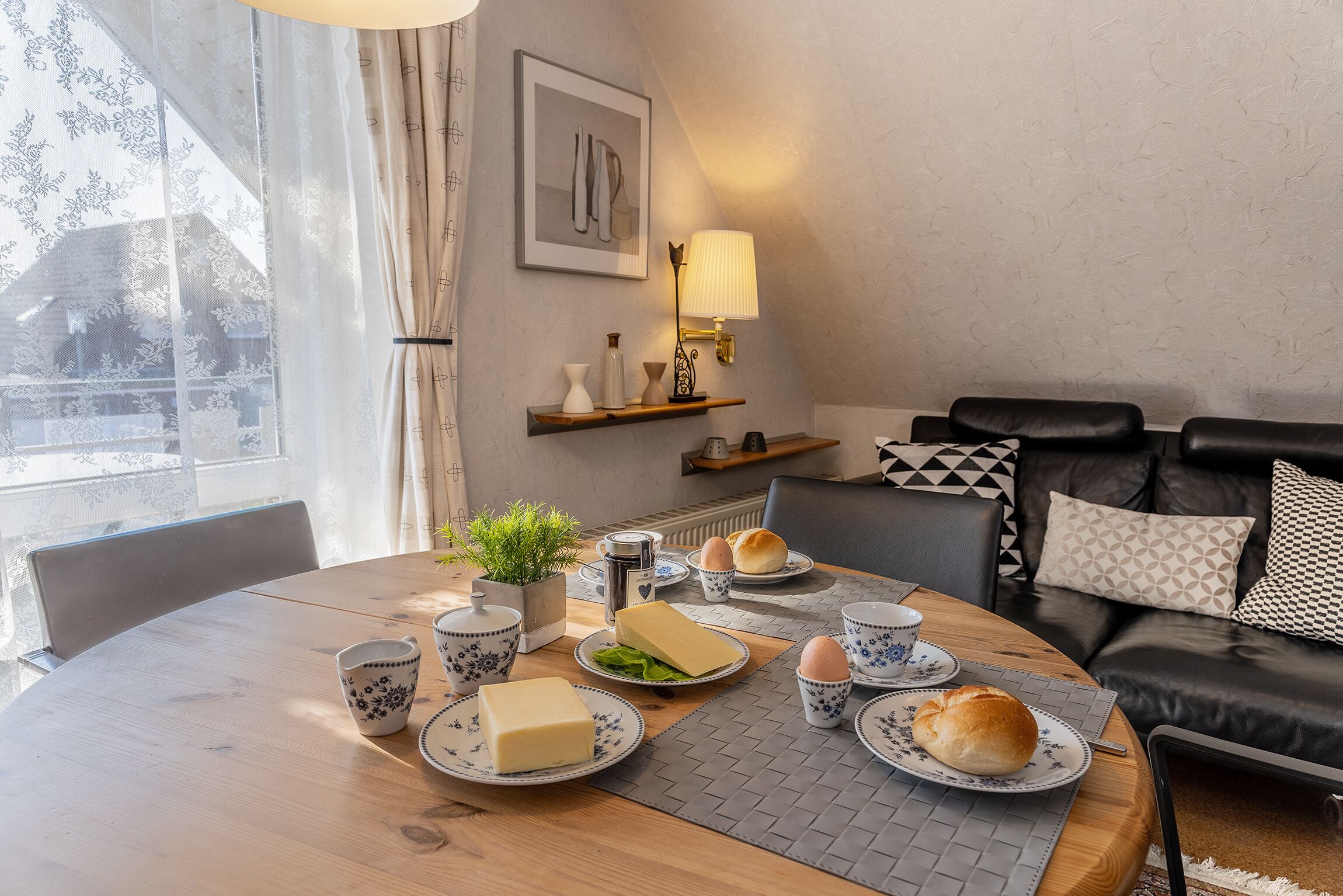 Une table à manger dressée avec des assiettes, des bols et une lampe.