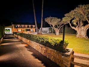 Un chemin menant à un bâtiment doté d’une terrasse et d’une piscine.