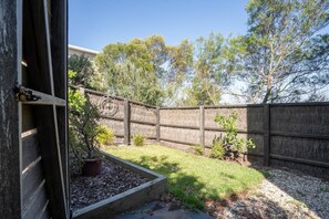 Enjoy a serene outdoor space surrounded by lush greenery and a garden.