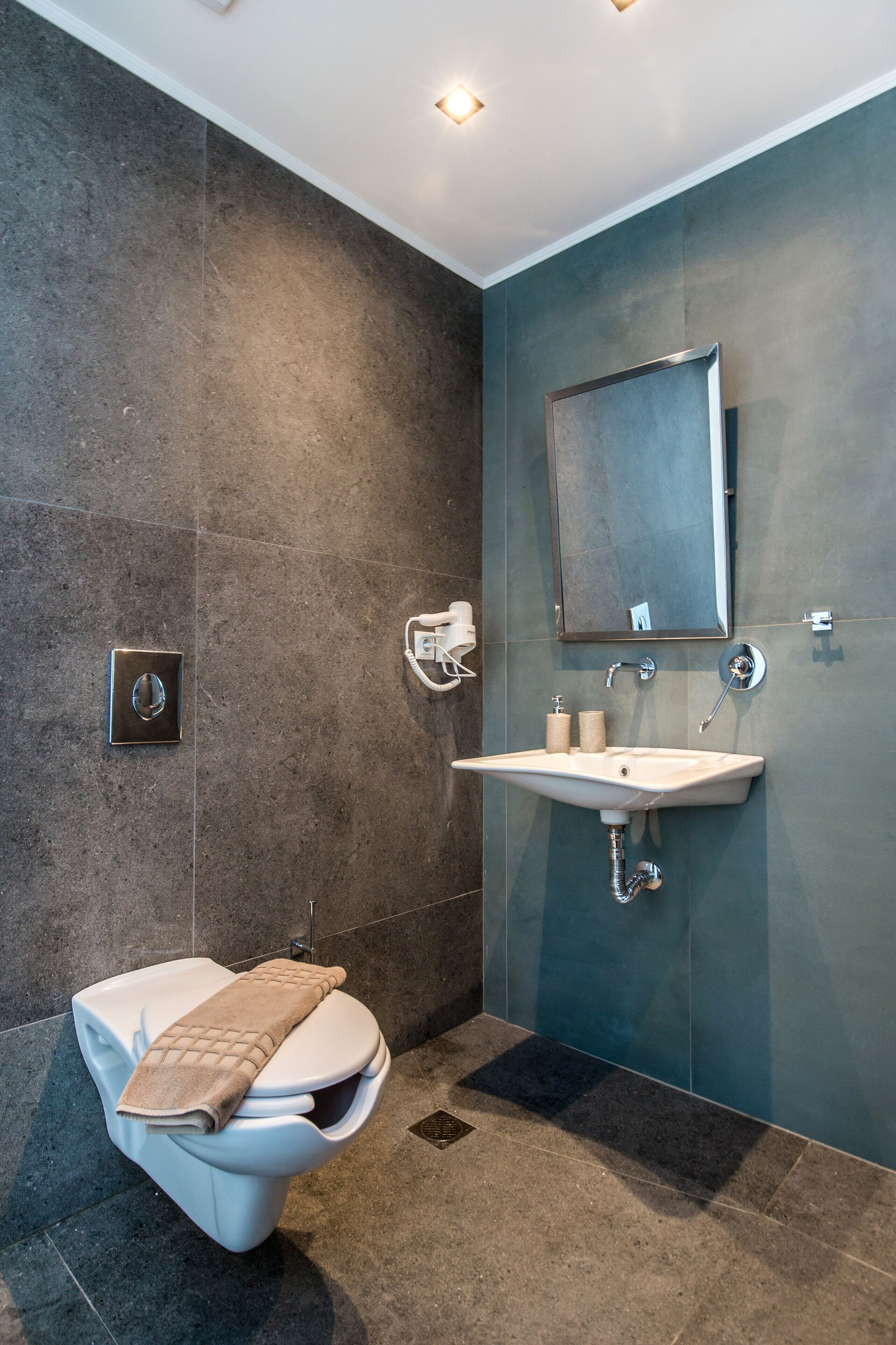 Un baño moderno con inodoro, lavamanos y espejo.