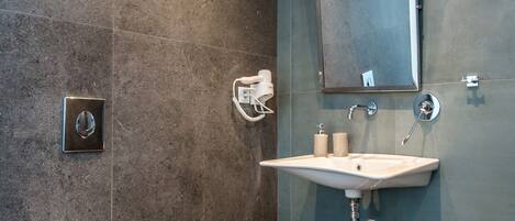 Un baño moderno con inodoro, lavamanos y espejo.