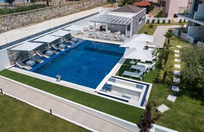 Relax by the pool surrounded by lush greenery and comfortable lounge chairs.