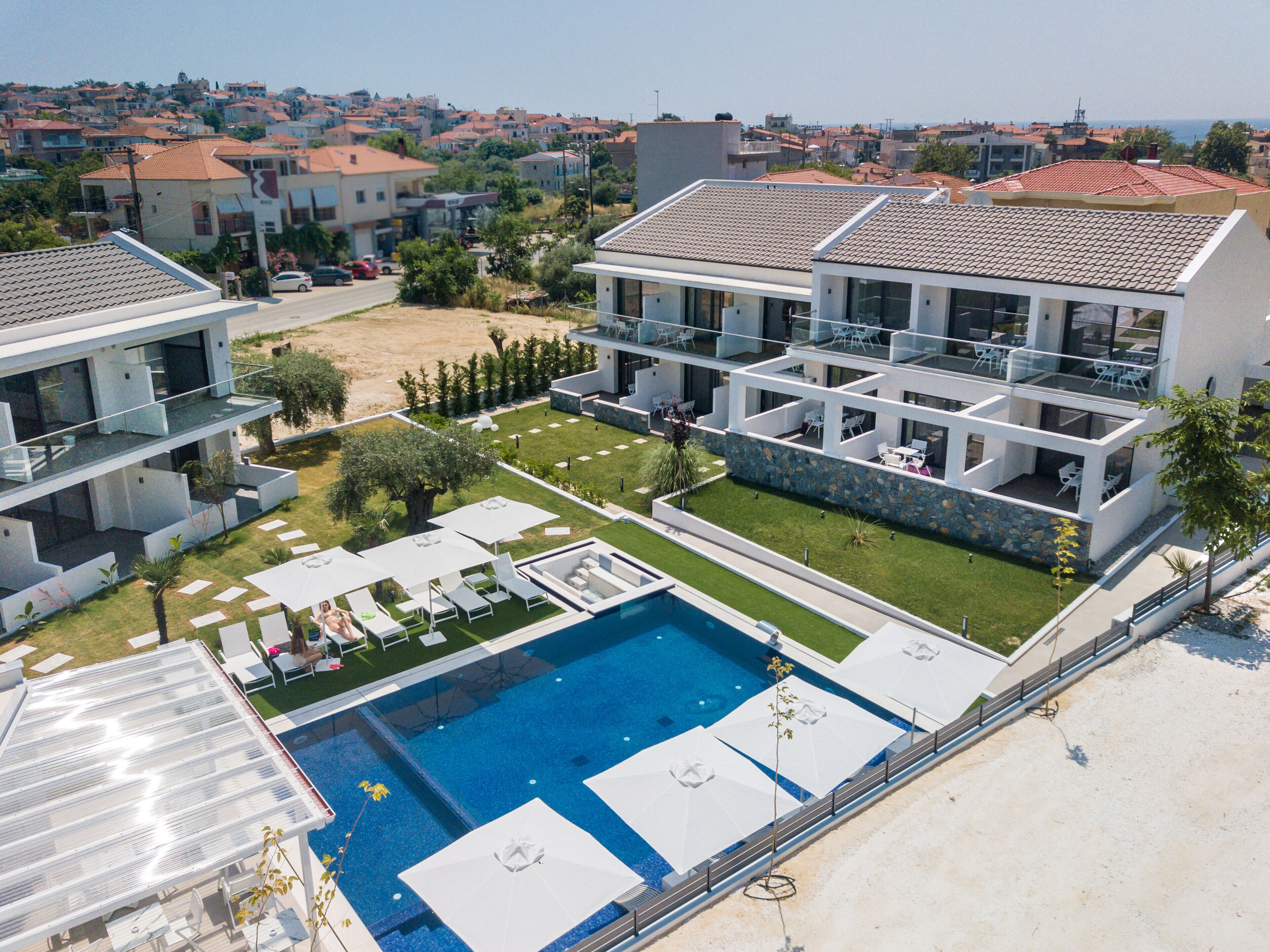 Ein modernes Hotel mit Schwimmbad, Außenbereich und Blick auf die umliegende Nachbarschaft.