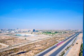 A highway with multiple lanes and a large building complex in the background.